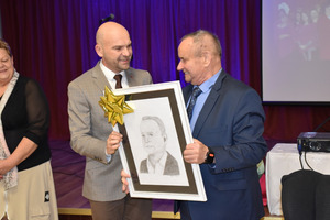 Wójt gminy Włoszakowice Marek Wąsowicz wręcza portret Zenonowi Polochowi